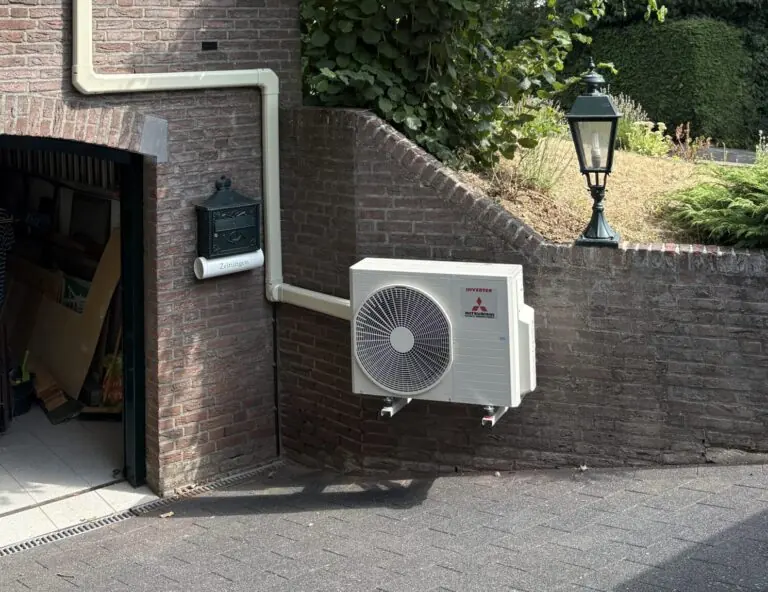Airco-buitenunit naast een garagepoort